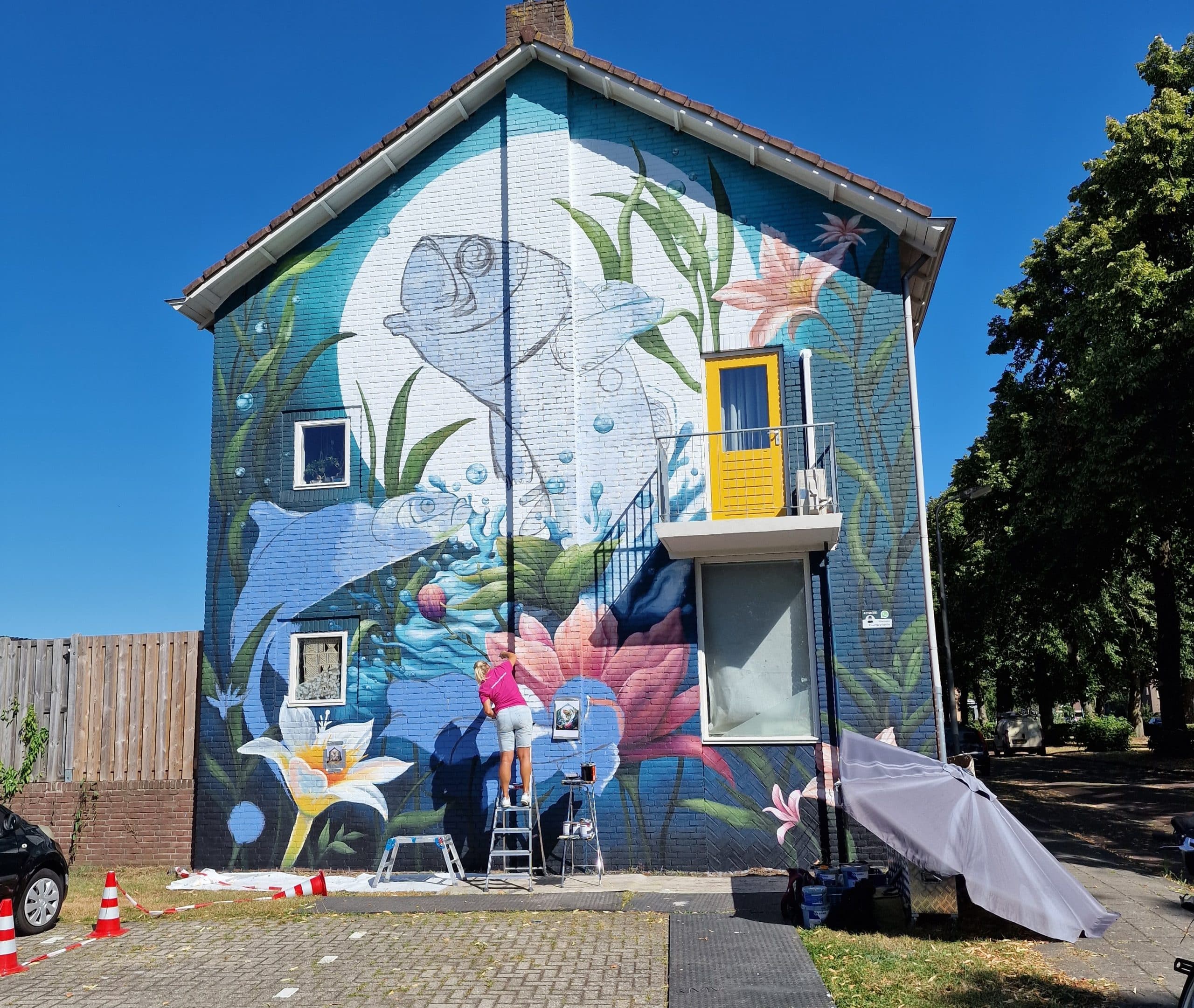 Muurkunstenaar Lonneke schildert de gevel in Haveltermade.